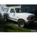 1989 Ford Bronco - This white 1989 Ford Bronco is parked in a driveway with a house in the background.