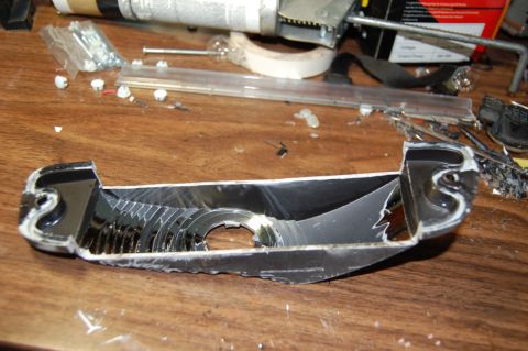 1985 Mercury Grand Marquis - A disassembled car part lies on a workbench with tools and hardware scattered around.