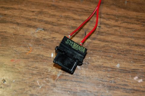 1985 Mercury Grand Marquis - Close-up of a Sylvania bulb socket with red wires, likely a car part.