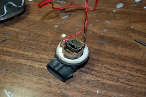1985 Mercury Grand Marquis - A close-up view of a wiring harness connector with exposed wires, resting on a workbench.