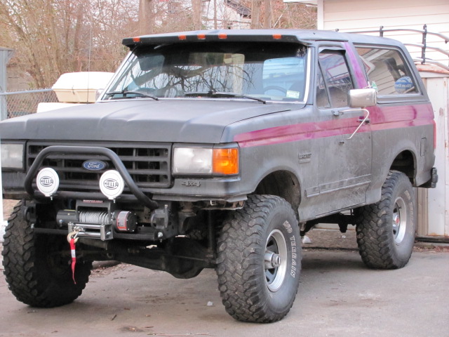 Gray Ford Bronco with purple stripe, lifted suspension, winch, and off-road tires