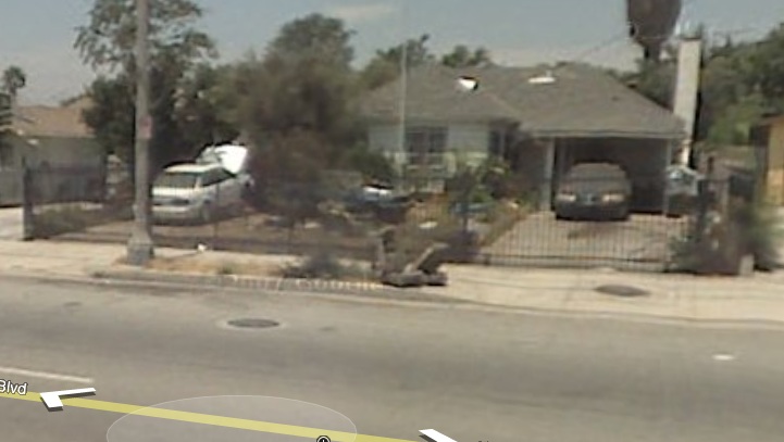 Street view of a house with a white van and a dark car in the driveway