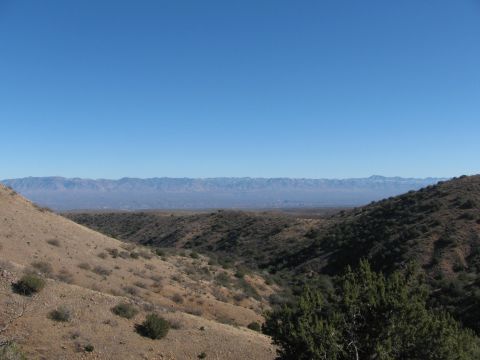 1996 Ford C-350 (Centurion Conversions) - A vast desert landscape unfolds with rolling hills and distant mountains under a clear blue sky.