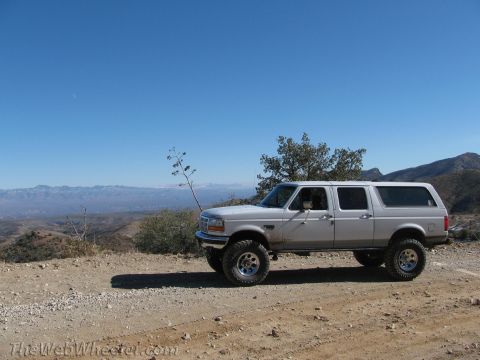 1996 Ford C-350 (Centurion Conversions) - Lifted 1996 Ford C-350 (Centurion Conversions) SUV parked on a dirt road overlooking a mountain range.