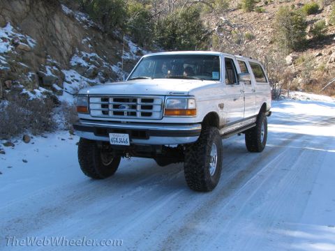 1996 Ford C-350 (Centurion Conversions) - A lifted 1996 Ford C-350 Centurion Conversions SUV navigates a snowy mountain road.