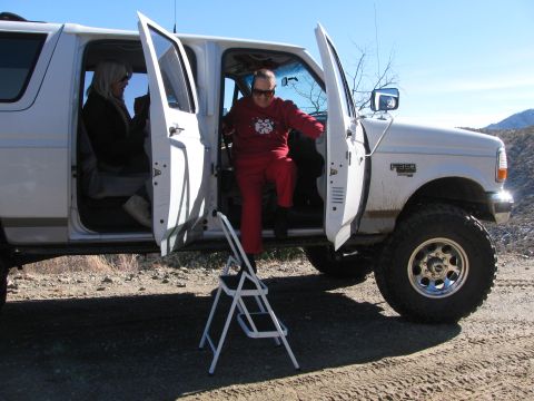 1996 Ford C-350 (Centurion Conversions) - People exiting a white 1996 Ford C-350 (Centurion Conversions) truck on a dirt road.