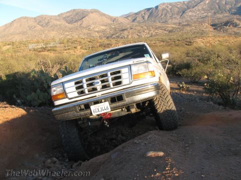 1996 Ford C-350 (Centurion Conversions) - White 1996 Ford F-Series truck tackling rough terrain on an off-road trail.