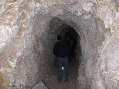 1996 Ford C-350 (Centurion Conversions) - Explorers venture into a dimly lit mine shaft with rough, natural rock formations.