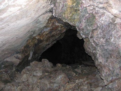 1996 Ford C-350 (Centurion Conversions) - Rocky cave entrance with debris. TheWebWheeler.com watermark is visible.