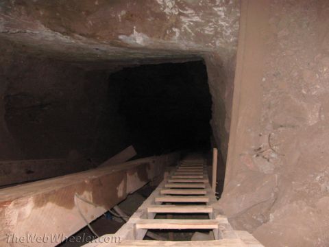 1996 Ford C-350 (Centurion Conversions) - A dark mine shaft with a wooden ladder leading into the unknown depths.