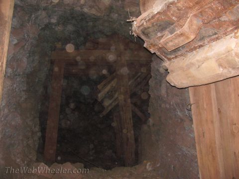 1996 Ford C-350 (Centurion Conversions) - Interior view of a mine shaft showing wooden bracing and the rough-hewn rock walls.