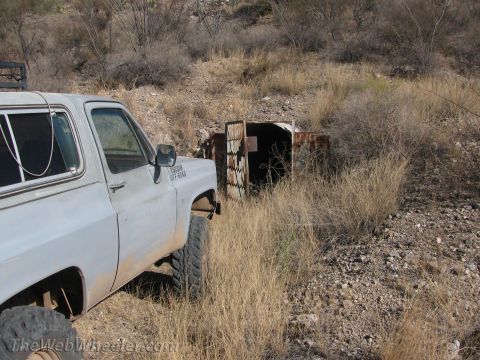 1996 Ford C-350 (Centurion Conversions) - Pickup truck parked in a dry, overgrown area next to a corrugated metal structure.