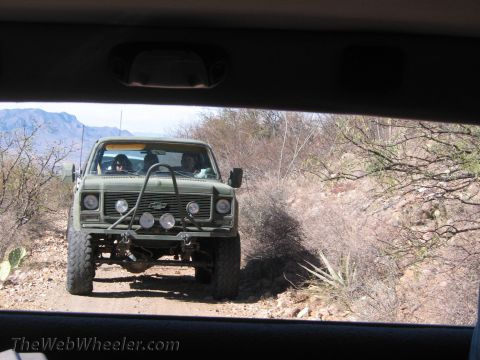 1996 Ford C-350 (Centurion Conversions) - Modified pickup truck navigates a dusty trail with mountains in the background.