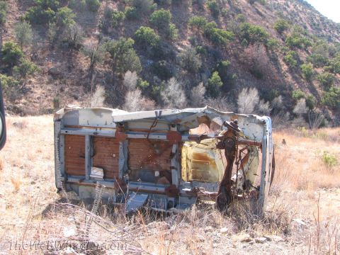 1996 Ford C-350 (Centurion Conversions) - This heavily damaged vehicle lies overturned in a dry, grassy landscape, its interior and chassis exposed.