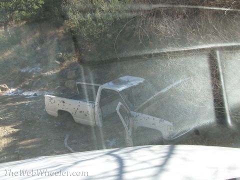 1996 Ford C-350 (Centurion Conversions) - This weathered white pickup truck appears abandoned off the side of a dirt road.