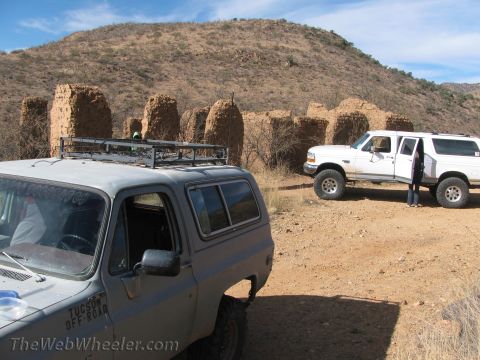 1996 Ford C-350 (Centurion Conversions) - Two off-road vehicles parked near historic adobe ruins under a bright blue sky.