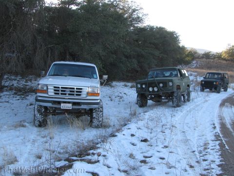 1996 Ford C-350 (Centurion Conversions) - Three 4x4 vehicles parked on a snow-covered dirt road during an off-road trip.