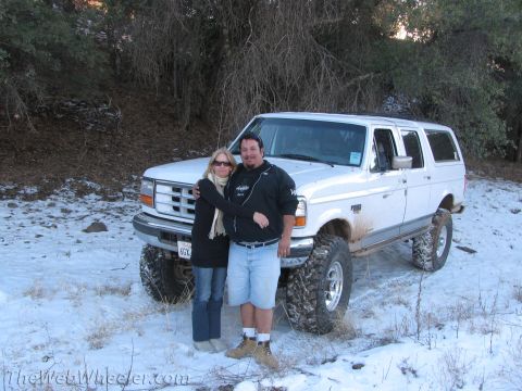 1996 Ford C-350 (Centurion Conversions) - A white Ford SUV is seen in a snowy landscape with two people posing in front of it.
