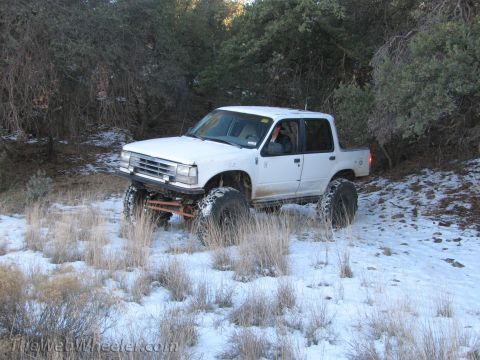 1996 Ford C-350 (Centurion Conversions) - This lifted pickup truck navigates a snowy, wooded trail.