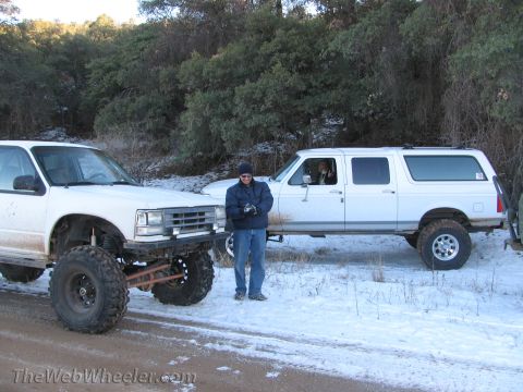 1996 Ford C-350 (Centurion Conversions) - Modified SUVs with off-road tires sit in a snowy, wooded landscape.