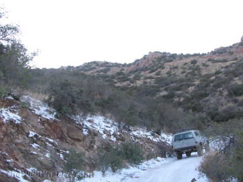 1996 Ford C-350 (Centurion Conversions) - SUV navigates a snowy mountain road during winter off-roading.