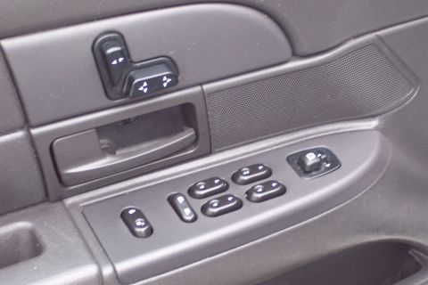 2001 Ford Crown Victoria - Close-up of the driver's side door panel showing power window and seat controls.