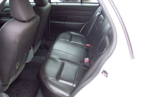 2001 Ford Crown Victoria - Interior view of the rear seats and door panel of a vehicle, likely a police car.