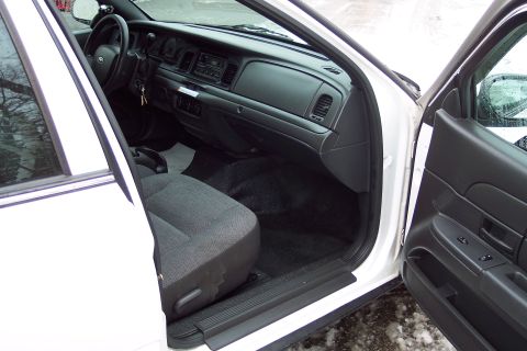2001 Ford Crown Victoria - The interior of a white 2001 Ford Crown Victoria is visible with the driver's door open.