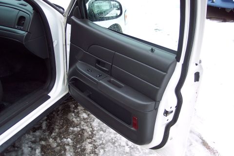 2001 Ford Crown Victoria - The interior door panel of a 2001 Ford Crown Victoria, showing the window controls and door handle.