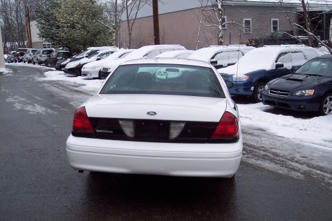 2001 Ford Crown Victoria - A white Ford Crown Victoria is parked in a snowy lot with other vehicles visible.