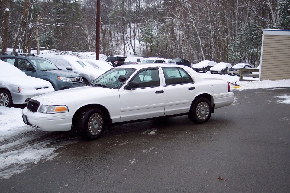 White 2001 Ford Crown Victoria sedan, 3/4 front view, parked in snow