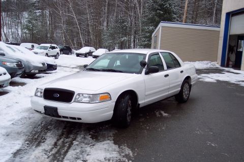 2001 Ford Crown Victoria - White 2001 Ford Crown Victoria police car in a snowy lot with other vehicles.