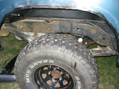 1986 Ford Bronco - Close-up view of the rear wheel well and suspension components, including a Mud Rover tire.