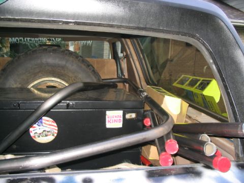 1986 Ford Bronco - Spare tire and roll cage visible inside the vehicle's cargo area.