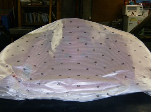 2000 Ford E350 - A vehicle is covered in protective wrapping, obscuring its details, with the Supermotors logo visible at the bottom.