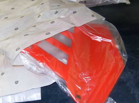 2000 Ford E350 - An orange plastic part, possibly a fender or fairing, is packaged for shipping.