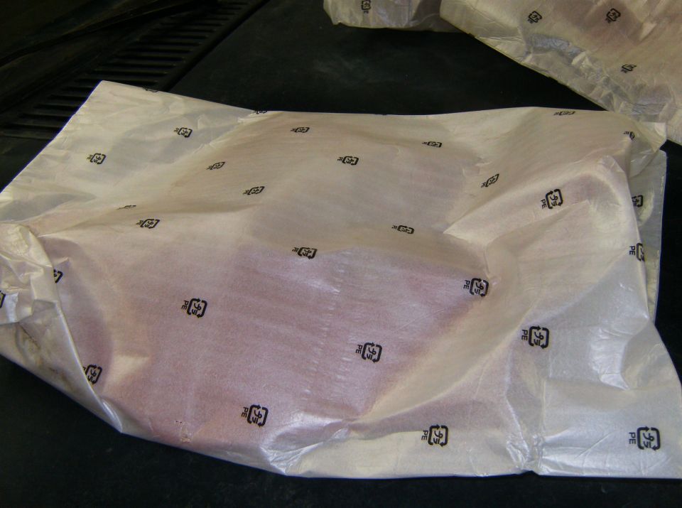 Part wrapped in plastic with recycling symbols