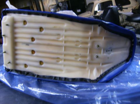 2000 Ford E350 - Underside of a blue seat cushion with visible foam and mounting hardware.