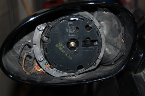 2002 BMW M3 - Close-up of a car's side mirror interior, showing the internal mechanism and wiring.