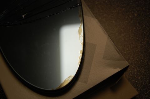 2002 BMW M3 - A damaged mirror, likely for a vehicle, is shown in its packaging.