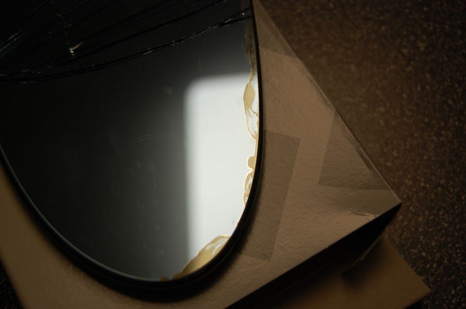 Close-up of black rubber gasket edge with tan sealant residue on cardboard box