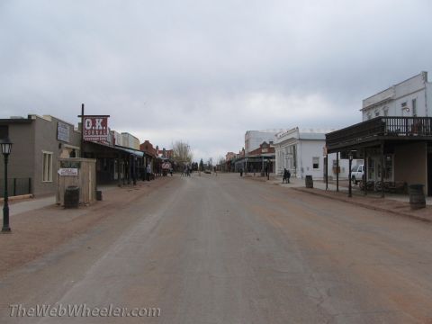 1996 Ford C-350 (Centurion Conversions) - A view down a dusty street lined with old west-style buildings under a cloudy sky.