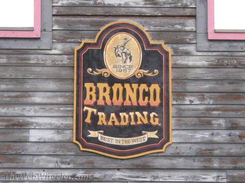 1996 Ford C-350 (Centurion Conversions) - A sign for Bronco Trading, established in 1957, is mounted on a weathered wooden wall.