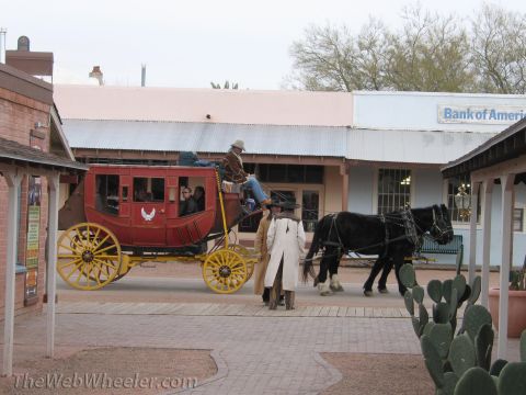 1996 Ford C-350 (Centurion Conversions) - A horse-drawn stagecoach travels down a street in a Western-themed town, with a Bank of America building in the background.
