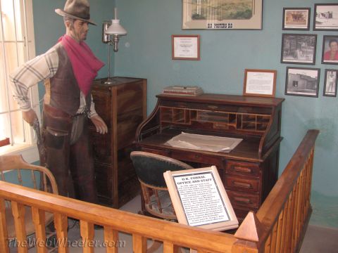 1996 Ford C-350 (Centurion Conversions) - A diorama depicts an Old West office scene with a mannequin cowboy, antique desk, and historical photographs on the wall.