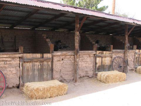 1996 Ford C-350 (Centurion Conversions) - A rustic stable scene depicts mannequins in cowboy attire within stalls, with hay bales and a wagon wheel outside.