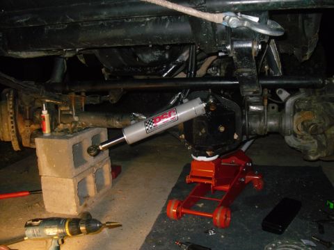 1984 Ford Bronco II - Close-up of a vehicle's steering linkage with a shock absorber installed.