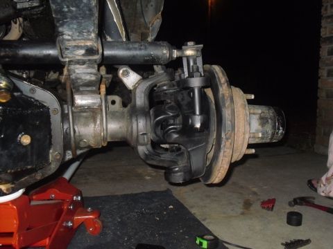 1984 Ford Bronco II - Close-up view of a vehicle's front axle steering mechanism, with a specialized tool engaged.