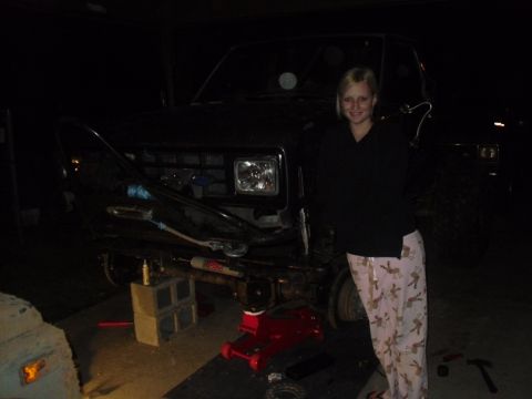 1984 Ford Bronco II - Front view of a 1984 Ford Bronco II being worked on, with a woman standing next to it.