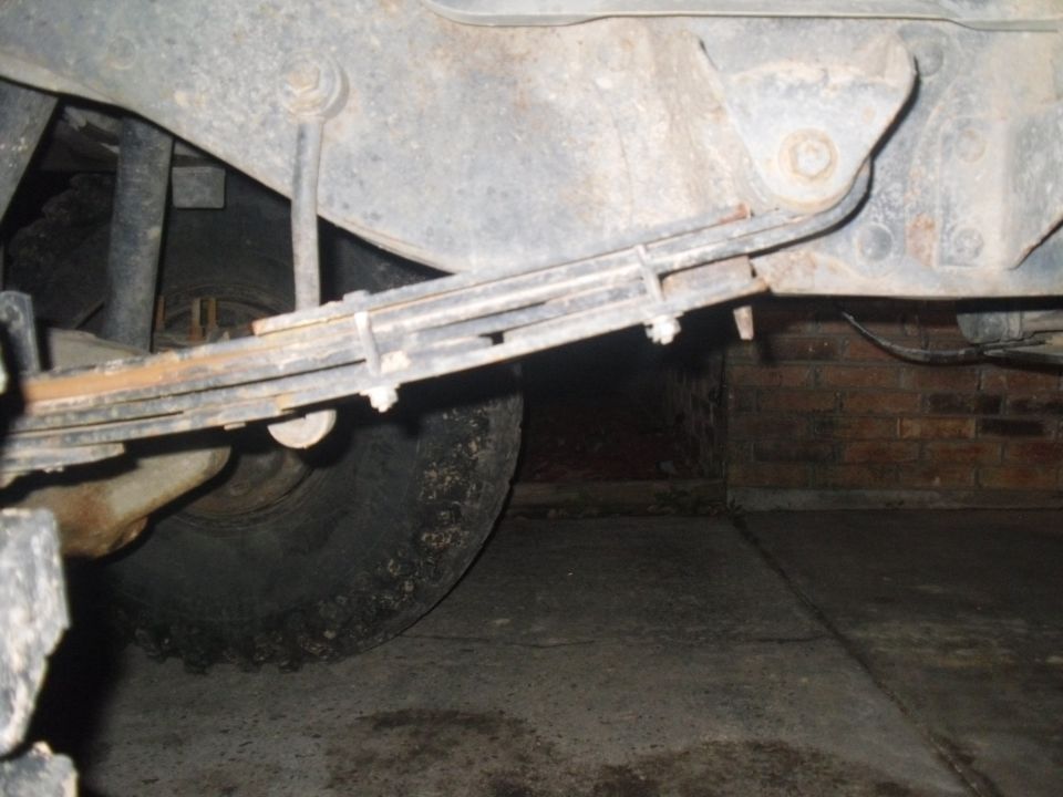 Close-up of a vehicle's leaf spring and tire